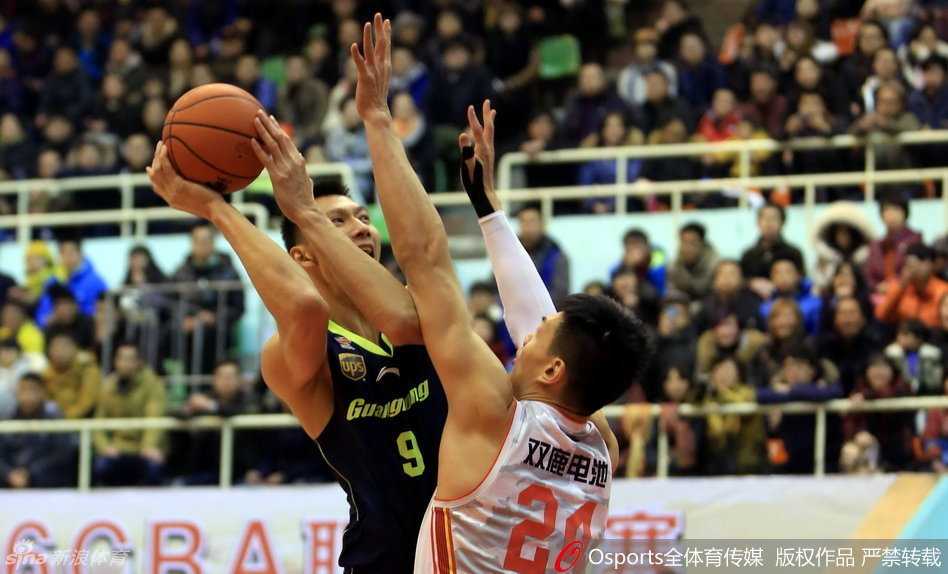 广东宏远核心易建联在八一分卫曹岩的紧逼防守下，依然神色坚毅地运球推进，眼神中透露出对胜利的极度渴望。