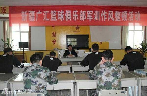 食堂后厨里，主教练李秋平没有一丝架子，他卷起袖子，认真地用清洁布擦拭着手中的餐盘，脸上挂着平和的笑容。这位在赛场上运筹帷幄的冠军教头，此刻正亲身践行着军营里人人平等的朴素作风。