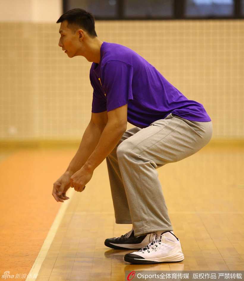 易建联在力量区进行负重深蹲训练，汗水已浸湿背心，大腿肌肉紧绷如雕塑，眼神坚毅地直视前方。