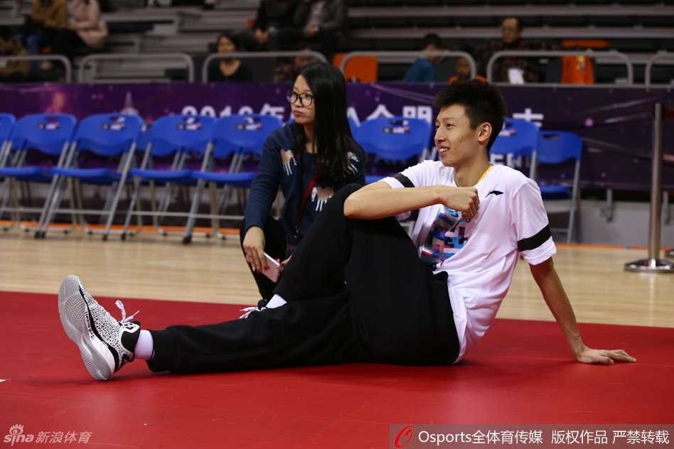 身披休闲装的周琦因伤无缘正赛，他坐在场边目光深邃，似乎在寻找着赛场上的某位故人或某个熟悉的战术，神色间难掩对赛场的渴望。