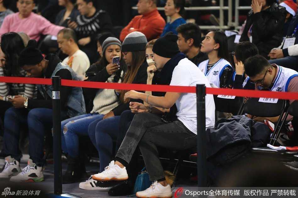 陈露戴口罩低头查看手机，却难掩出众气质，休闲打扮在人群中显得简约而不简单。