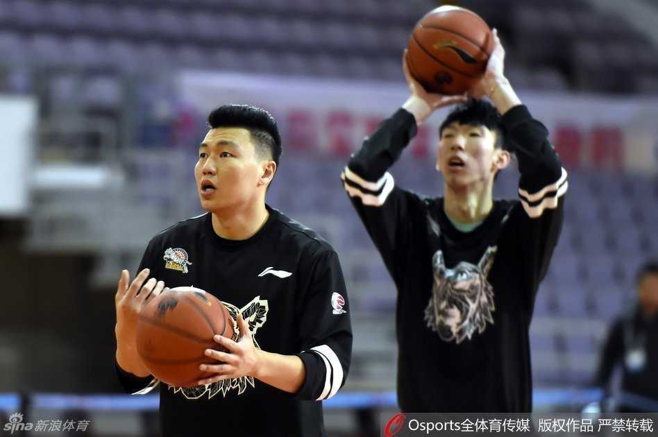大魔王周琦与李根在球场一侧专注地进行投篮练习，周琦修长的身影在空荡的球馆里格外醒目。