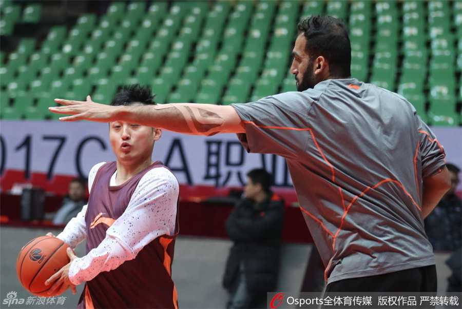 伊朗中锋哈达迪暂停期间手持战术板，神情专注地为队友画跑位路线，颇有几分助教风范。