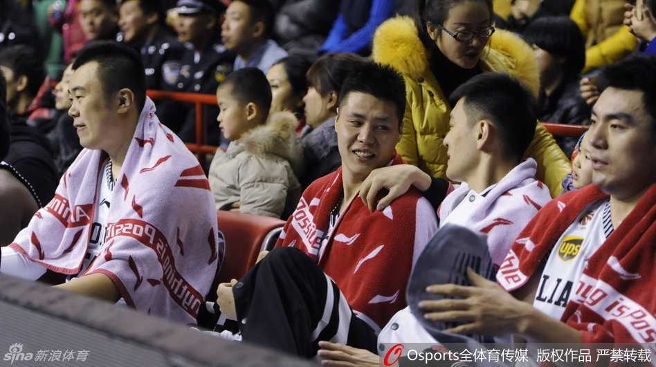 郭士强在场边拿着战术板，神情严肃地为球员讲解战术