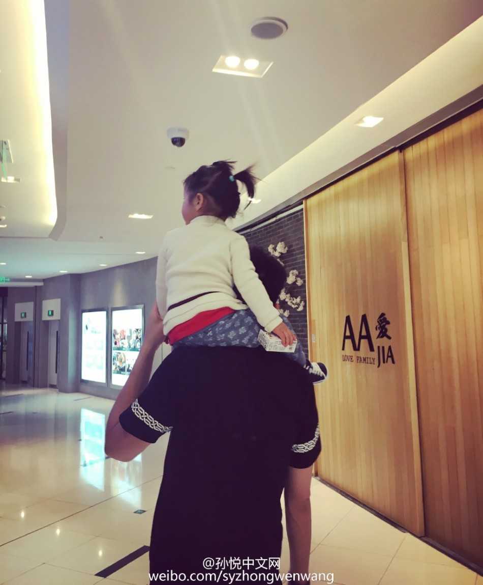 午后的休闲时光，孙悦戴着墨镜尽显酷爸本色，怀中的小月亮穿着可爱的碎花裙，好奇地打量着镜头，父女俩同框的画面既有型格又有爱意，反差感十足。