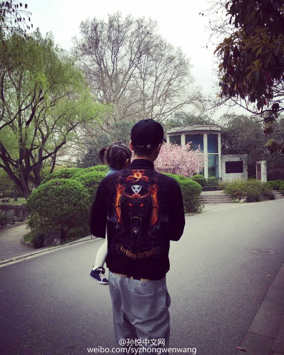 小小年纪的“小月亮”坐在五彩斑斓的海洋球池中，如同一个落入凡间的小精灵。她手里拿着一个海洋球，眼神纯净而好奇，身后的名牌卡片上用拼音写着“yue liang”，记录着她最初的成长印记。