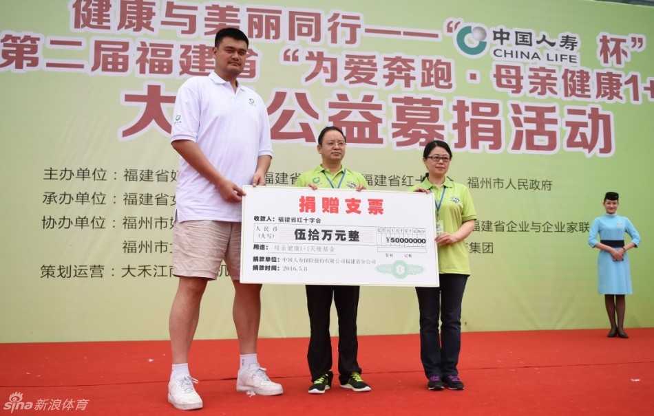 姚明双手紧握领跑旗，目光坚毅地望向远方，他身后的背景是蔚蓝的天空和整装待发的爱心跑者方阵，旗帜上的公益标语在阳光下格外醒目。