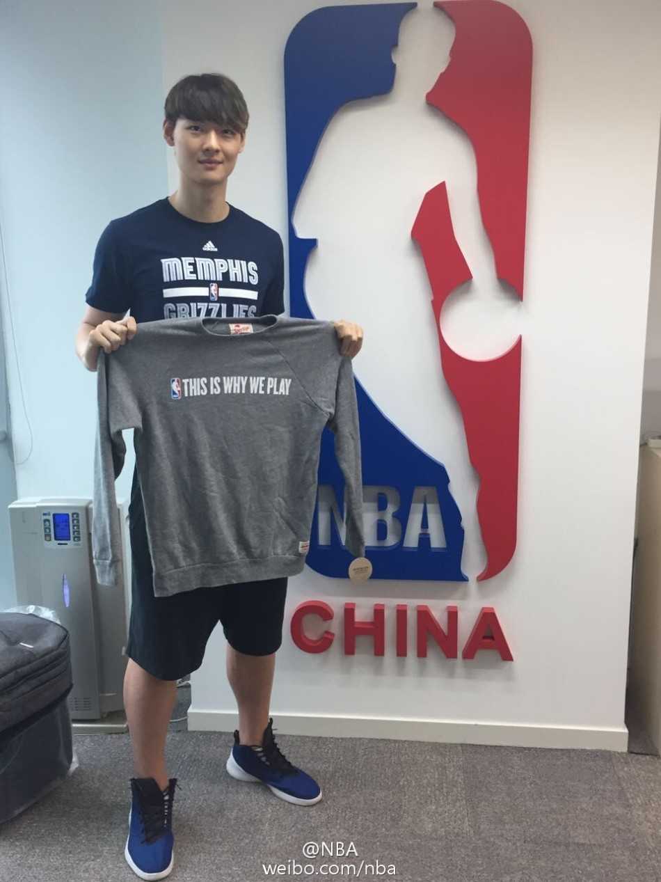 站在NBA中国总部的标志前，王哲林的身姿显得格外挺拔，这张合影是他篮球人生新篇章的郑重落笔。