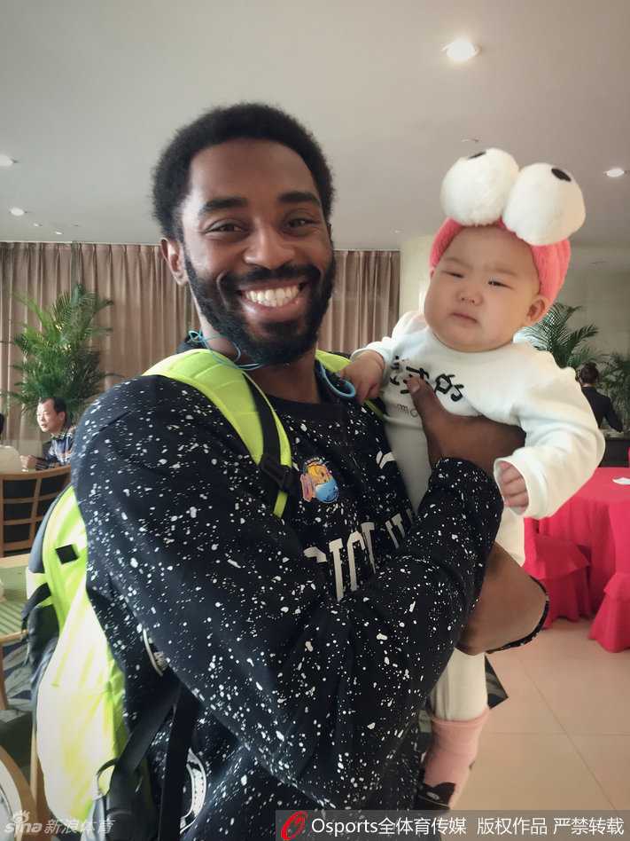 小公主被一位戴着眼镜的叔叔抱着，她显得十分乖巧，不哭不闹。身后的孟达和队友们看着这温馨的一幕，脸上都洋溢着轻松愉快的笑容，整个画面充满了大家庭般的融洽与暖意。