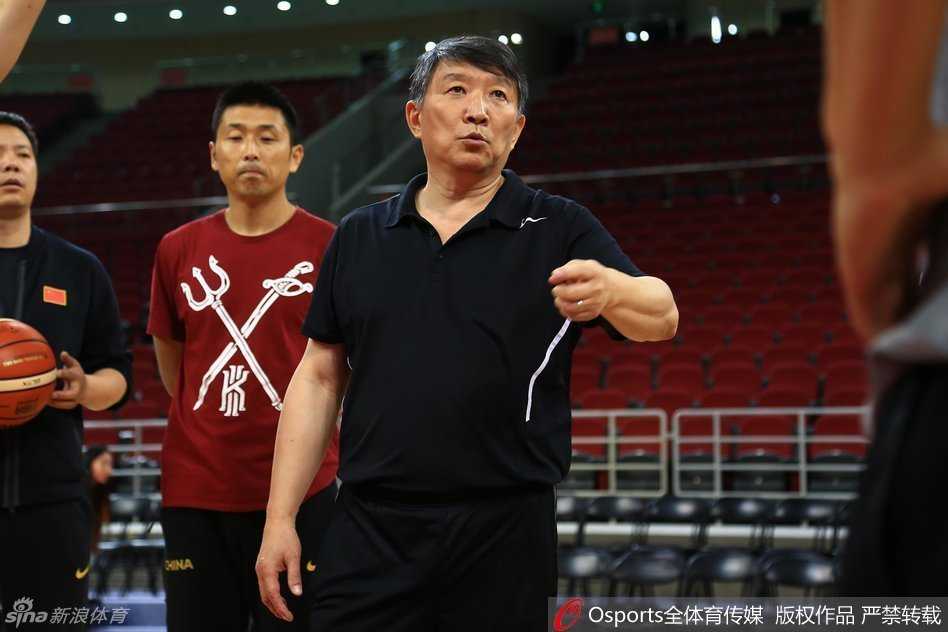 宫鲁鸣指导双手抱胸站在场边，神情严峻地监督着队员们的体能训练，不放过任何偷懒的细节