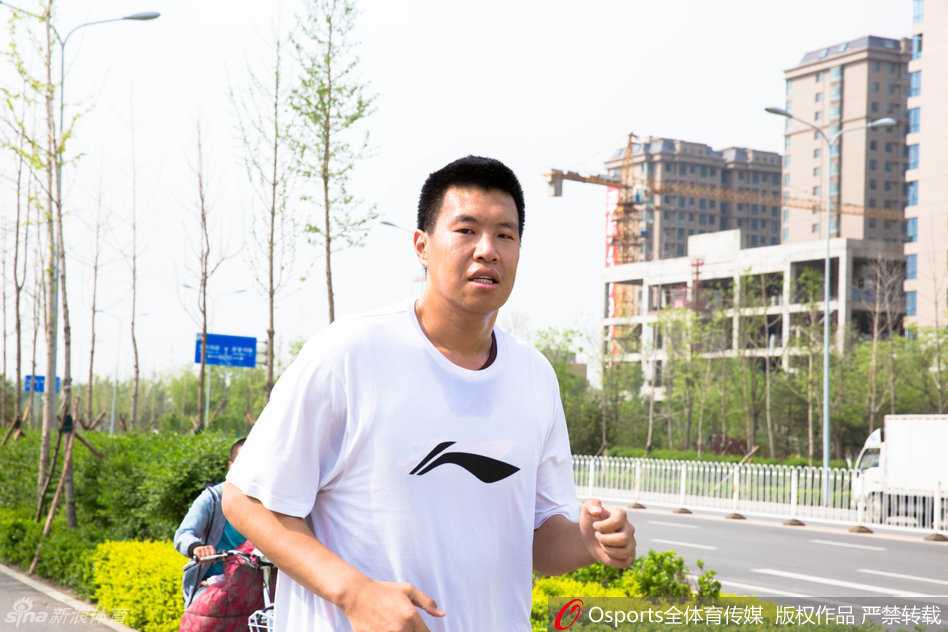 队长张学文在快攻中腾空而起，尽管汗水已打湿他的球衣，但他的眼神依旧坚毅，奋力将球送向篮筐。