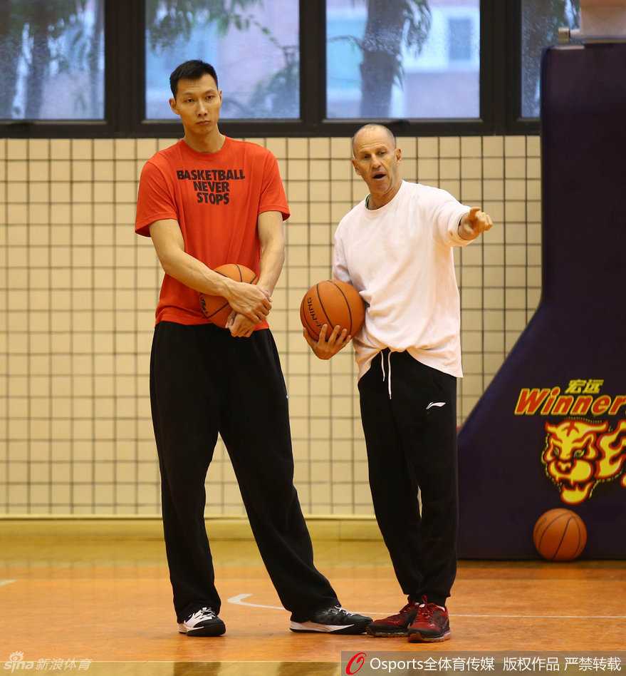 助教戈尔亲身示范防守动作，外援卡特在旁专注模仿，眼神中充满求知欲