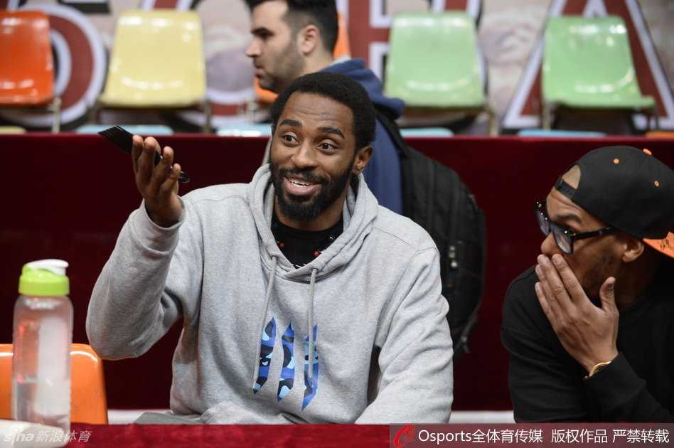 哈里斯在教练身后挤眉弄眼，将手搭在杨学增指导的肩上，做出夸张的鬼脸，而杨指导则一脸严肃地指挥战术，形成了极具戏剧性的师徒反差萌