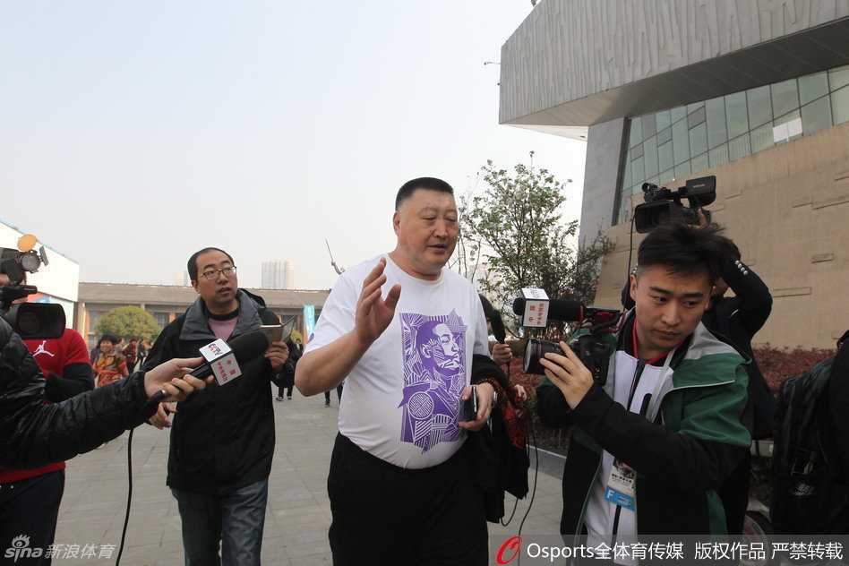 安保人员组成了一道人墙，努力将激动的记者与教练组隔开，其中一名戴眼镜的工作人员神情紧张，用尽全力维持着秩序。