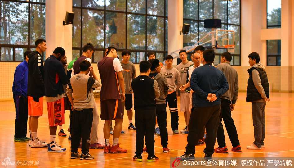 后卫陈江华在进行赛前拉伸热身，表情专注，身体舒展，为即将到来的高强度对抗做好充分准备。