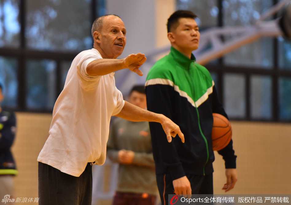 助教戈尔神情专注，激情四射地挥动手臂，大声呼喊指挥着广东男篮队员们的跑位与战术配合。