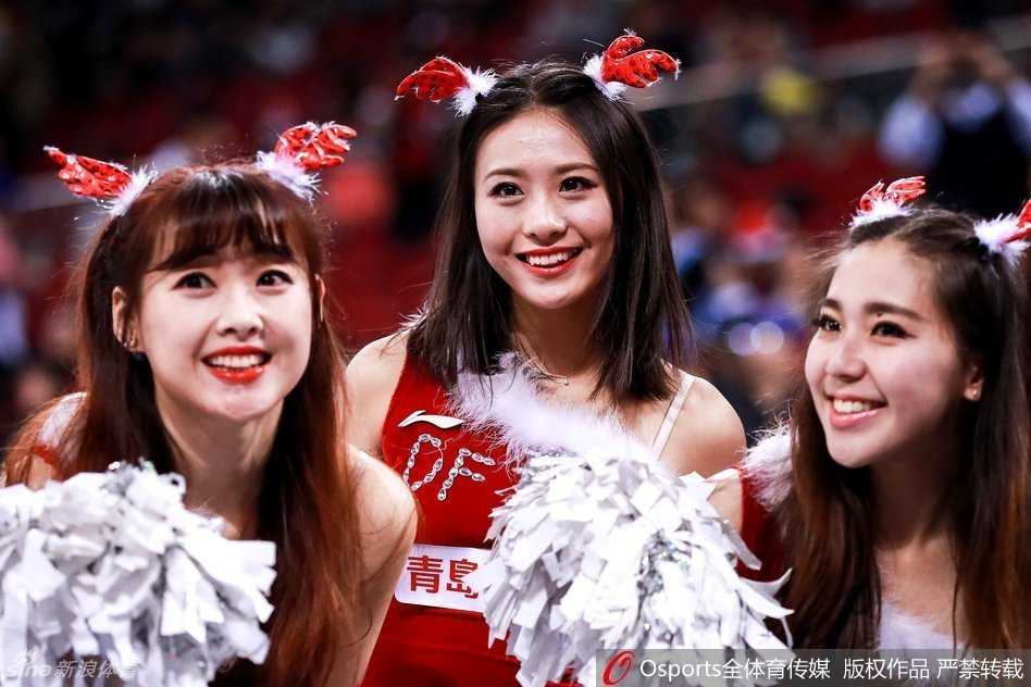 特写一位正在舞动的拉拉队员，她红色的圣诞短裙在灯光下格外鲜艳，飞扬的发丝展现出舞动的动感与活力。