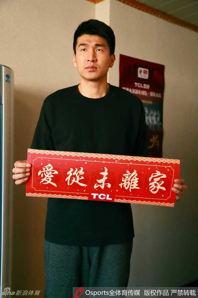 俞长栋在休息区被一位女球迷拦住合影，他双手自然垂下，脸上挂着略带羞涩又开心的笑容，眼神中透露出被球迷喜爱的满足感。