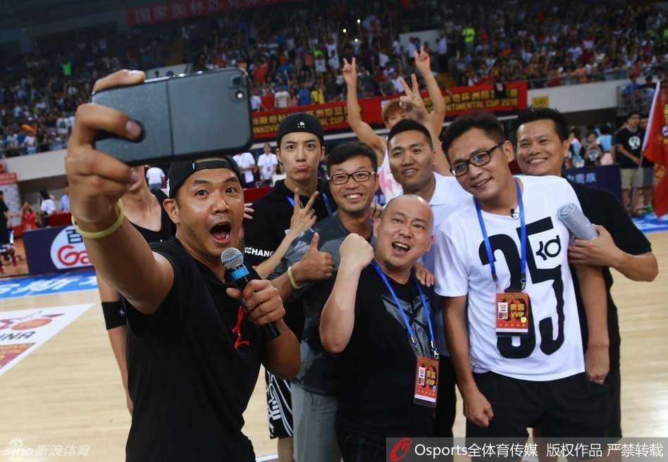 球场边，身着一袭黑衣的“黑人”陈建州全神贯注地盯着赛场方向，双手紧握成拳仿佛比场上的球员还紧张，眉宇间流露出曾经作为职业球员的那份专注与渴望，为每一次精彩进攻暗自鼓劲。