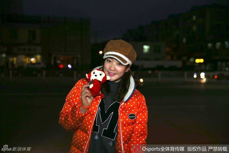 女篮队员李梦肩背手提多个行李包裹，在雪后抵京报到，眼神坚定地奔赴集训驻地。