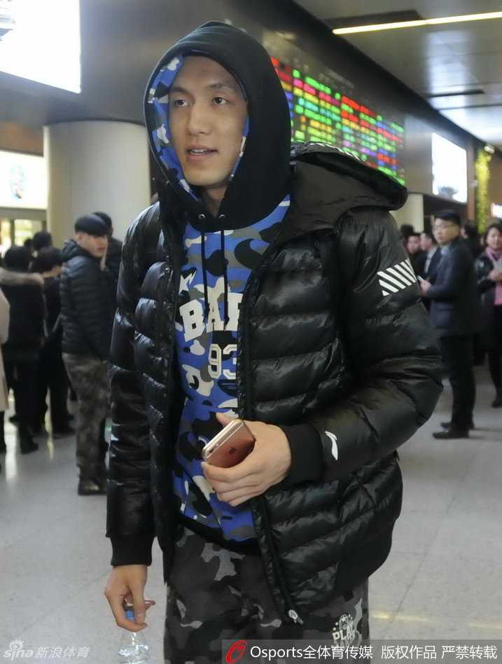 一位年轻的辽宁女球迷高高举着一块手绘的白色标语牌，上面用彩色画笔写满了对辽宁男篮的支持话语，她踮起脚尖，眼神中满是期盼，努力让自己准备的标语能被球员们看见。