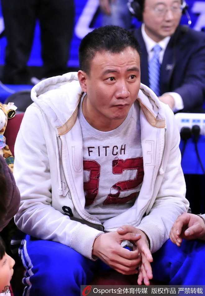 导演兼演员大鹏在场边举着手机忙于自拍，背景是即将进行最后一场全明星赛的王治郅，他试图用镜头捕捉这一充满纪念意义的瞬间。