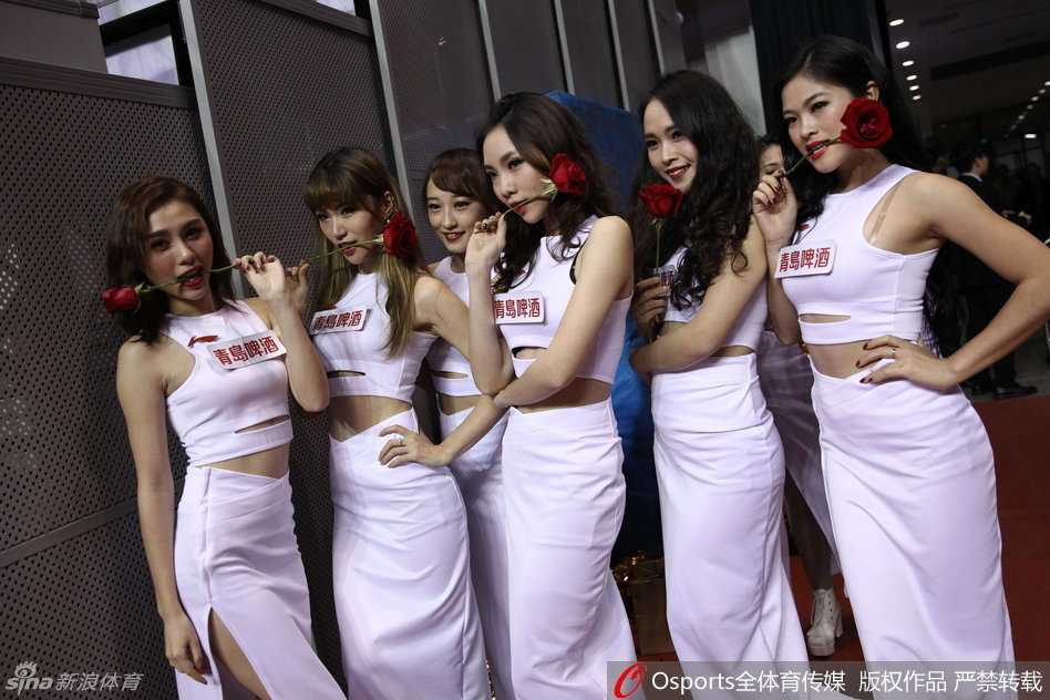 场边的美女记者同样是一道亮丽的风景线，她身着干练的服装，依然难掩傲人的身材，手持话筒正在专注地进行赛前报道，职业范儿十足。