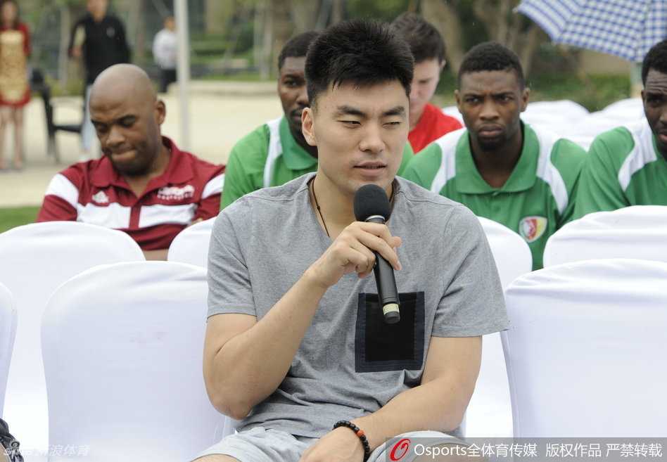 轮到李晓旭发言时，他侧身对着韩德君说着什么，脸上露出标志性的‘坏笑’，似乎在分享一个有趣的笑话。