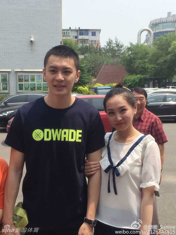 杨鸣面带微笑，身体微微前倾，专注地为热情的小球迷在球衣上签下自己的名字，举手投足间尽显球星风范。