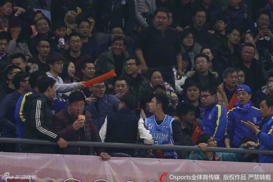 多名球迷在座椅间扭打成一团，有人被推倒在台阶上，安保人员奋力挤进人群，张开双臂试图分开双方，但冲突仍在持续