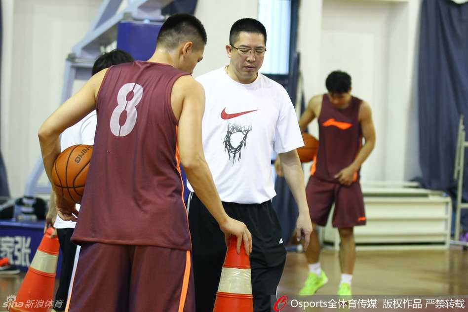 主帅胡卫东亲自上阵，在训练场上拉着一位年轻队员的面罩，神情严肃地进行战术布置，眼神中透露出对细节的极高要求。