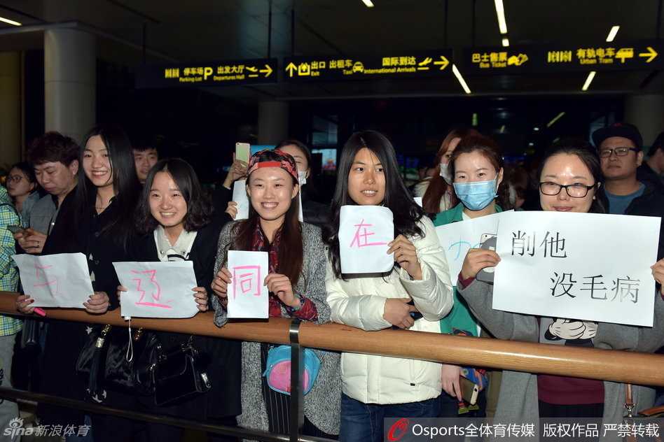 众人翘首以盼的接机现场，人群簇拥着标语，空气中弥漫着焦急与关切，所有人都在等待着那三个最熟悉的身影出现。