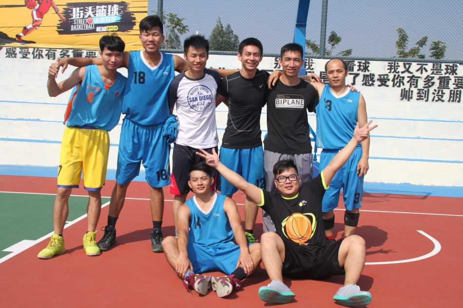 赛场上球员们拼抢倒地后，两队队员迅速围拢过来互相拉起对手，场边的队友伸出手递上水瓶补充能量，画面充满兄弟情谊