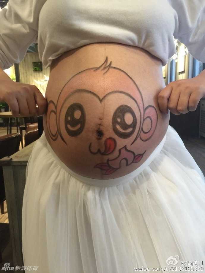 孕妈在江南风格的庭院中侧身而立，肚皮上的小猴子图案格外显眼，甜美的笑容与静谧的景色融为一体，完美诠释了“甜美写真”的主题。