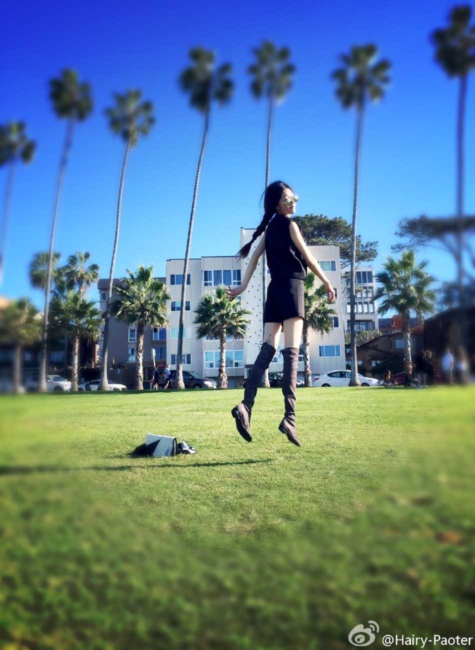 李跑身着时尚服饰漫步街头，随性的姿态中透露出大气与从容，仿佛自带光芒的都市风景线。