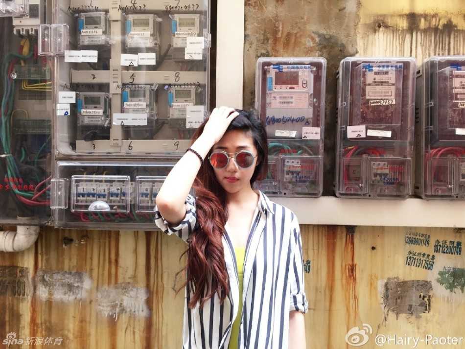 李跑站在一片自然风光中，身姿挺拔，她轻轻侧身，一双美腿在光影交错中显得白皙动人，笑容里满是旅行的喜悦。