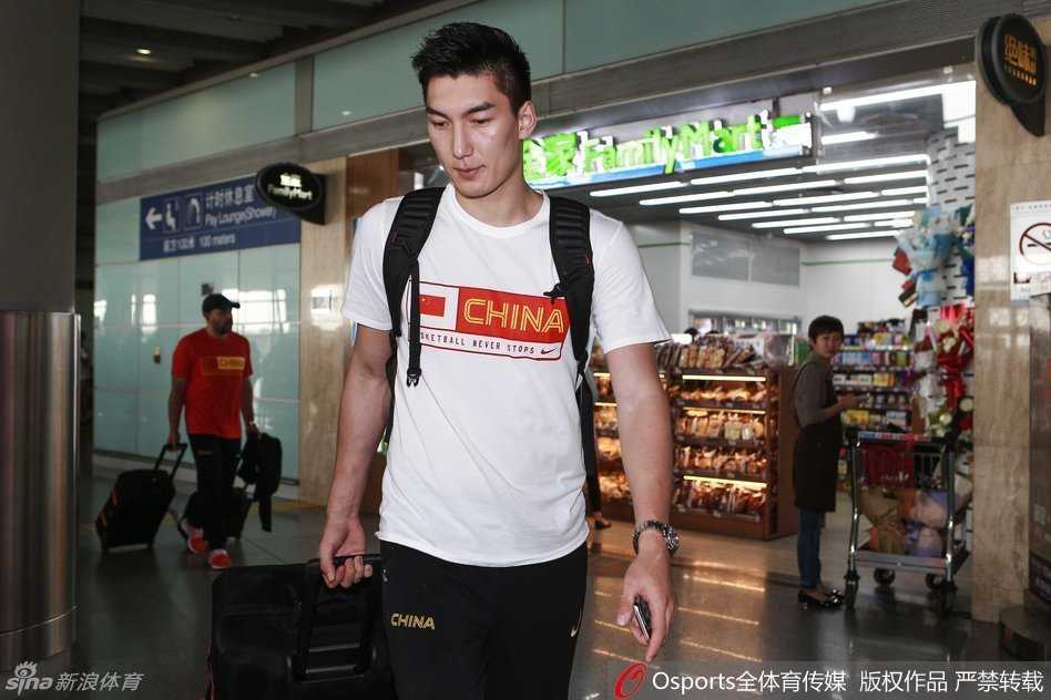 郭艾伦毫无偶像包袱地蹲在地上刷手机，神情专注得像个孩子，身后的赵大鹏正在接听电话，画面充满了生活气息，展现了球星们赛场外的真实一面。