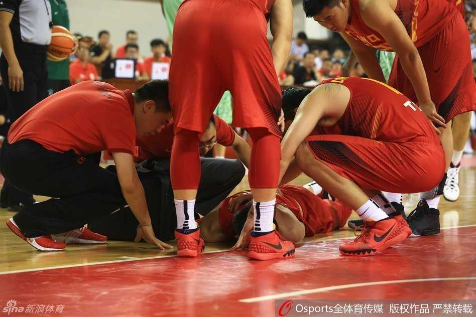 队医半蹲着为周琦进行最后的冰敷处理，周琦的表情依然有些凝重，但相比刚受伤时已经舒缓了许多，他望向球场的方向，内心或许还在牵挂比赛的胜负。