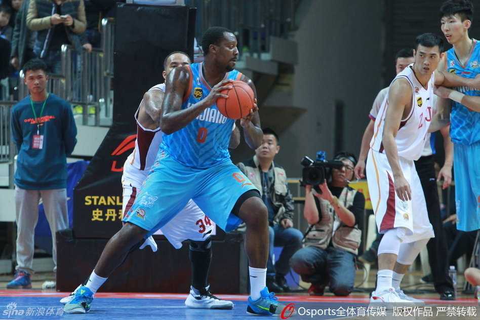 新疆队外援布拉切在浙江队内线群中强行转身，利用厚实的身板扛开防守，眼神坚毅地盯着篮筐，准备完成一次势在必得的强攻。