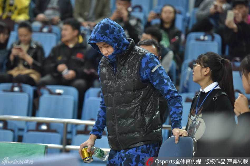 郭艾伦低着头，专注地研究着手里的棒棒糖，仿佛那不是一根普通的糖果，而是一件需要认真对待的“宝贝”，身后的赛场喧嚣似乎都与他隔离开来。