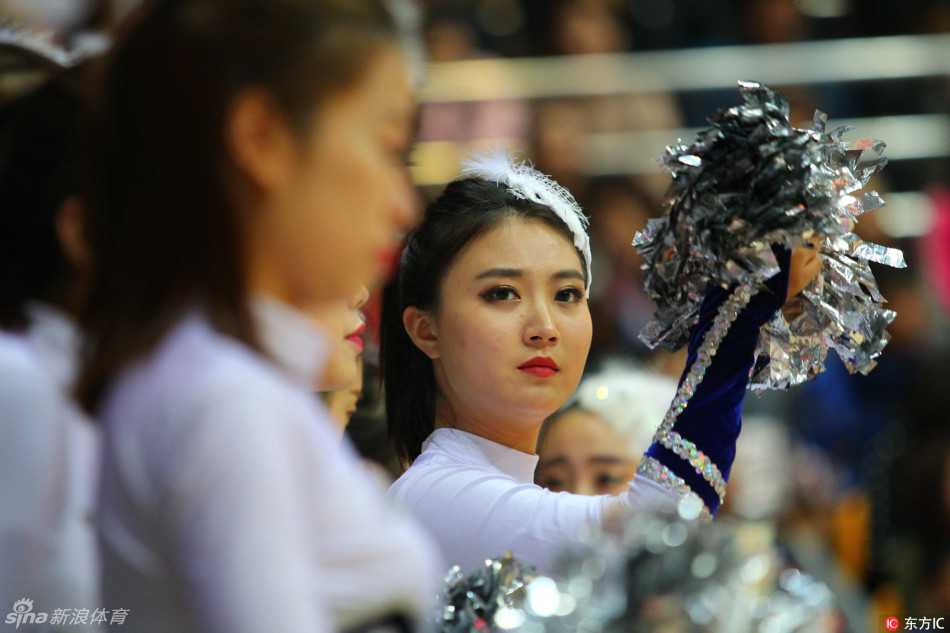 聚光灯下，一名篮球宝贝回眸一笑，额前的刘海随着动感节奏轻轻摇曳，眼神中流露出的是自信与娇媚，仿佛在向看台上的观众发出热情的邀请。