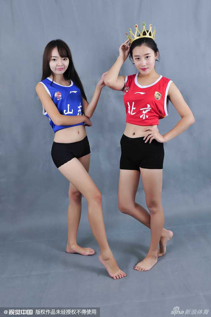 换上白色热裤套装，宝贝们的造型更显活力。两人背靠背站立，眼神坚定地望向前方，展现出篮球宝贝特有的飒爽英姿，仿佛在说：赛场上的主角虽是球员，但我们也准备好了最热情的表演。