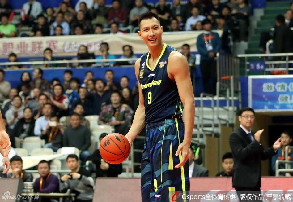 易建联在对手严密包夹下，嘴角露出一丝无奈的微笑，眼神中却依然透露着对胜利的渴望。