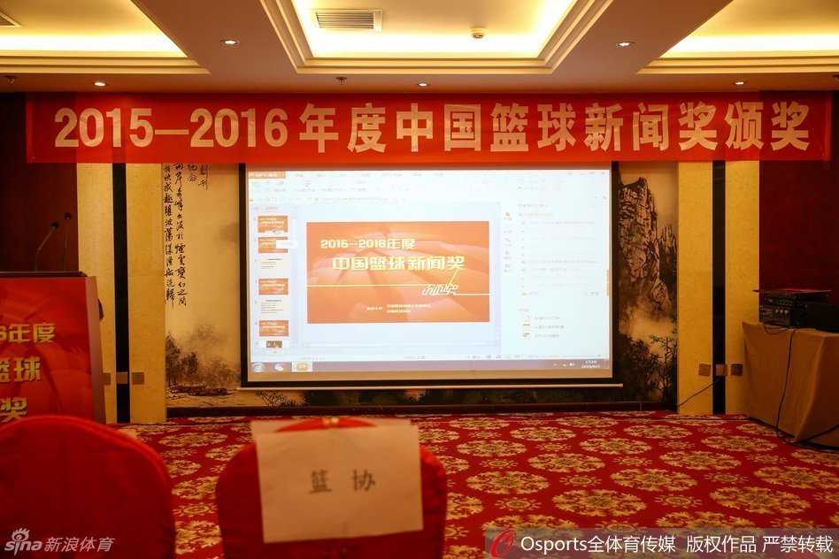 仪式的尾声，获奖者与颁奖嘉宾共同站在台上，掌声与快门声交织成一曲动人的乐章。画面前景中的奖杯熠熠生辉，背景里的笑容真诚而热烈，共同构成了这幅属于中国篮球媒体人的辉煌画卷。