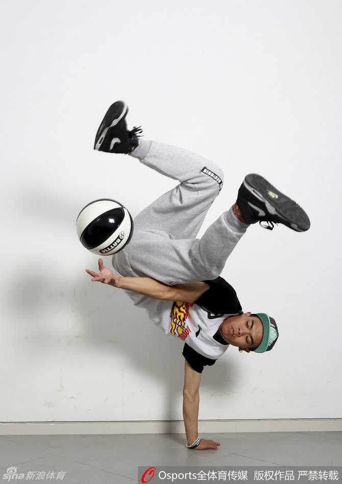 身穿白色表演服的花式篮球队员双手运双球，动作整齐划一，他们身后的看台上坐满了身穿白色助威服的球迷，整个球馆弥漫着大战前的紧张与期待。