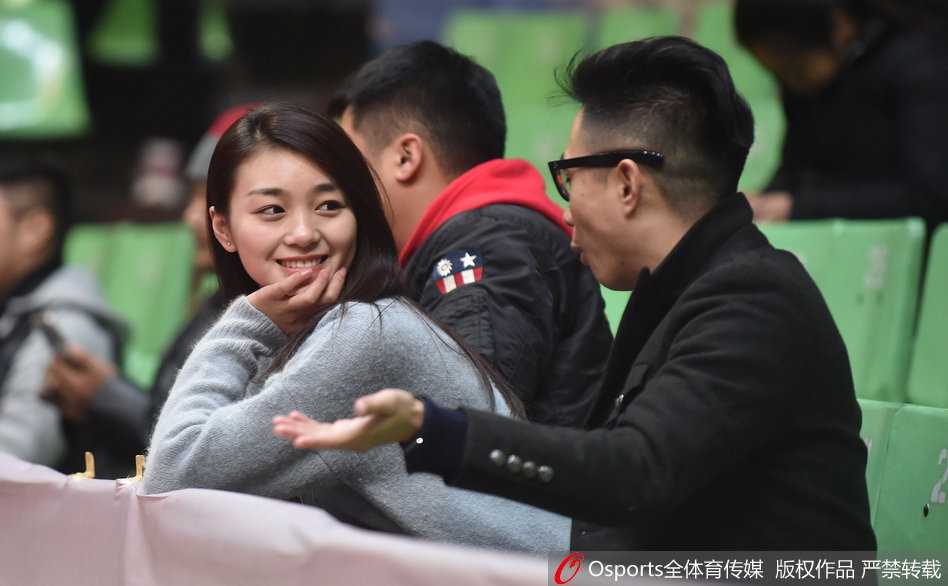 一位长发披肩的四川美女球迷，在主场喧嚣的背景下，回眸一笑，眼神中闪烁着对主队胜利的渴望与自信，仿佛一道温暖的阳光洒在座位上。