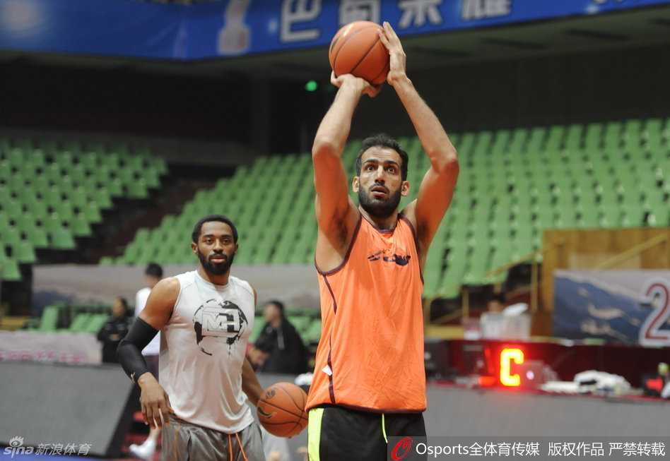 哈达迪在罚球线附近跳投出手，体态舒展，身后的训练标语和空旷的座椅构成背景，脸上洋溢着的笑容仿佛预示着一场胜利即将到来。