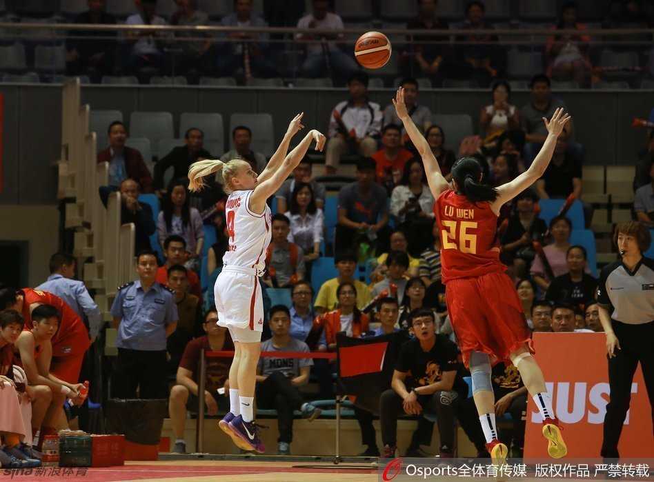 中国女篮队员外线果断出手，篮球在空中划出优美弧线