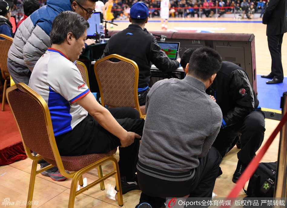 工作人员背着受伤裁判离开球场，裁判无力地伏在背上，留下一个令人印象深刻的落寞背影