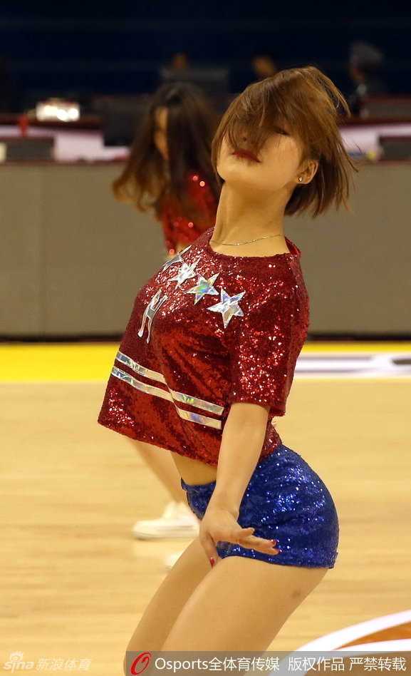 篮球宝贝回眸瞬间，眼神中带着自信与坚定，火辣身材在灯光下显得格外耀眼。